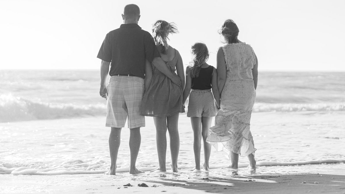 man and woman walking on beach during daytime